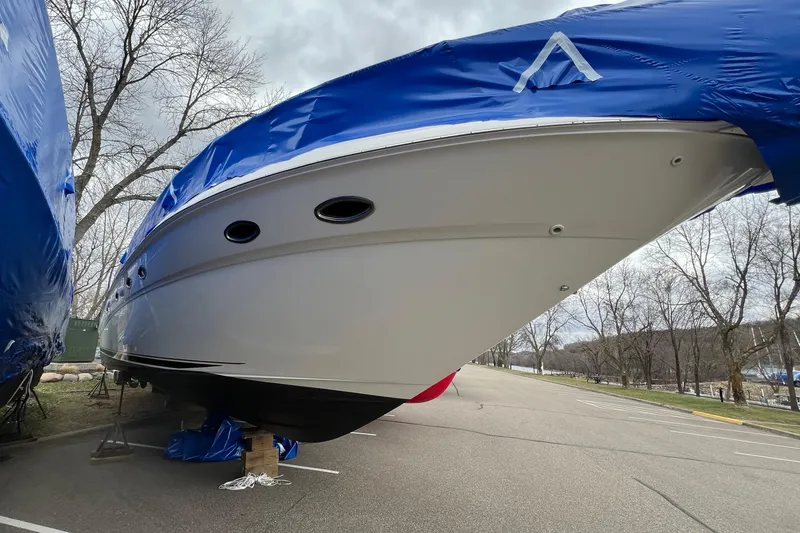 Slide: The Image of 2000 Sea Ray Sundancer 460 yacht covered in blue tarp, parked on a paved area. - 11