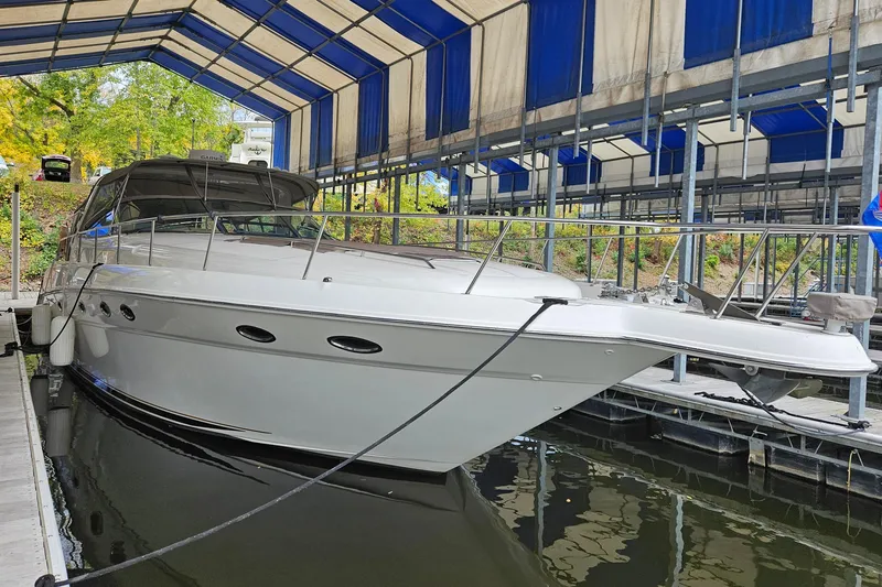 Slide: The Image of 2000 Sea Ray Sundancer 460 yacht docked under a blue canopy. - 2