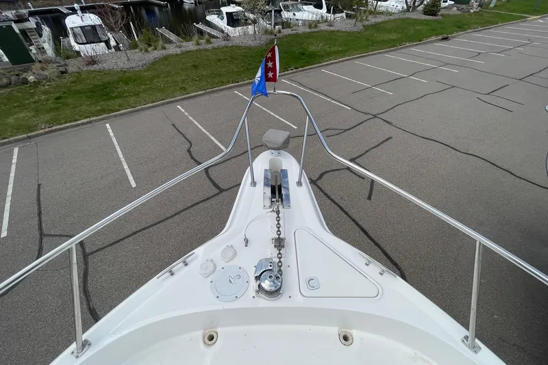 Slide: The Image of Bow view of a 2000 Sea Ray Sundancer 460 yacht in a parking lot. - 21