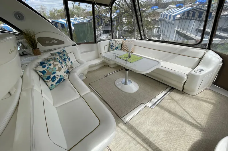 Slide: The Image of Luxurious interior of 2000 Sea Ray Sundancer 460 yacht with plush seating and scenic marina view. - 24
