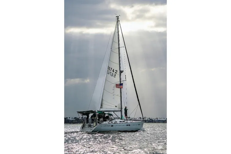 Slide: The Image of Sailing yacht Beneteau 423, 2007 model, gliding on shimmering water under cloudy sky. - 1