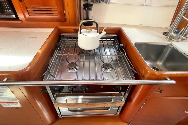 Slide: The Image of Galley kitchen in 2007 Beneteau 423 sailboat with stove and kettle. - 23