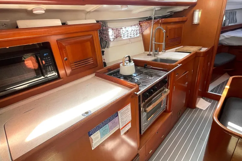 Slide: The Image of Interior of a 2007 Beneteau 423 yacht kitchen with stove, sink, and microwave. - 24