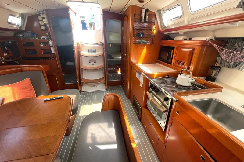 Slide: The Image of Interior of 2007 Beneteau 423 sailboat with kitchen, dining area, and wooden cabinetry. - 28