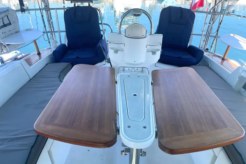Slide: The Image of Cockpit of 2007 Beneteau 423 sailboat with wooden table and cushioned seating. - 8