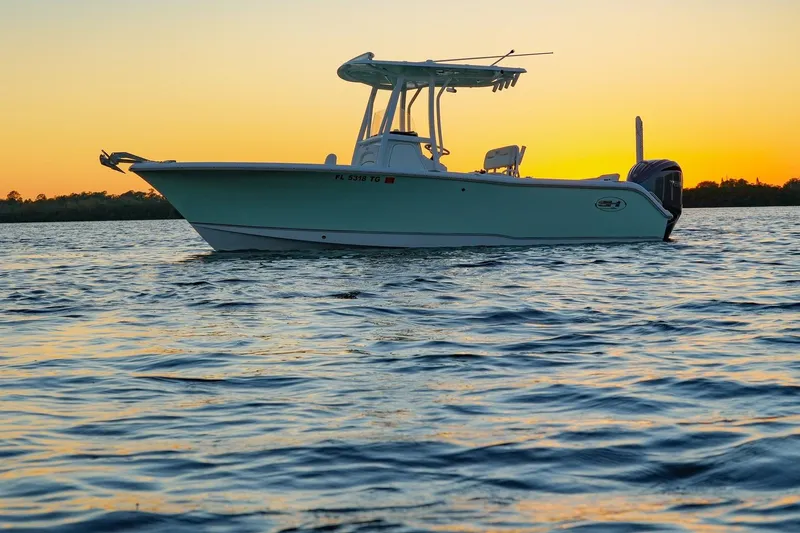 The Image of 2022 Sea Hunt Ultra 229 boat on water at sunset. - 1