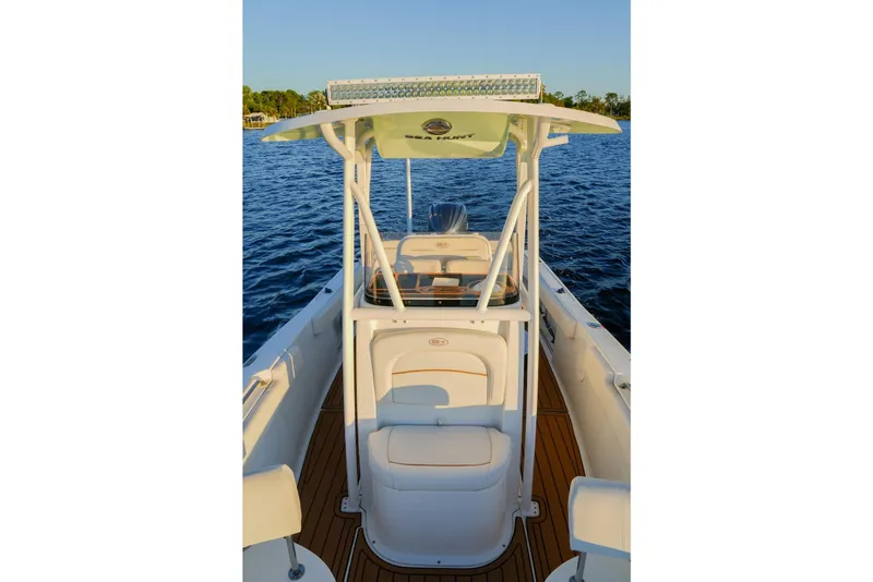 Slide: The Image of 2022 Sea Hunt Ultra 229 boat interior with seating and console on water. - 10