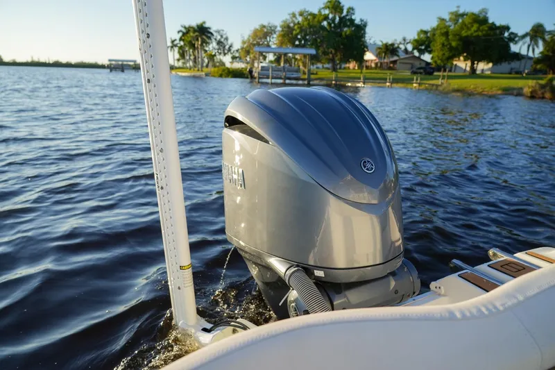 Slide: The Image of 2022 Sea Hunt Ultra 229 boat with Yamaha outboard motor on a serene lake. - 13