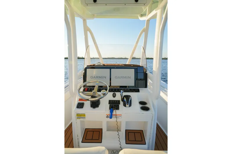 Slide: The Image of 2022 Sea Hunt Ultra 229 boat dashboard with Garmin navigation system on calm water. - 9