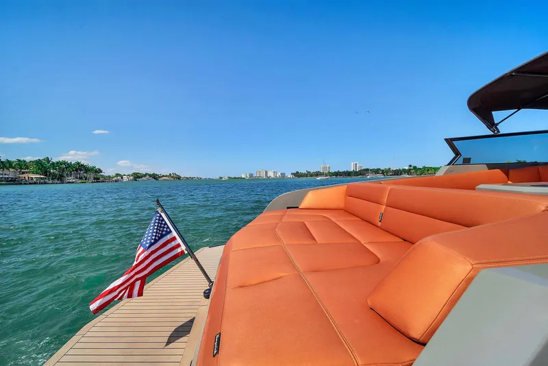 Slide: The Image of 2021 Vanquish Yachts VQ 45 with orange seating, American flag, and scenic water view. - 26