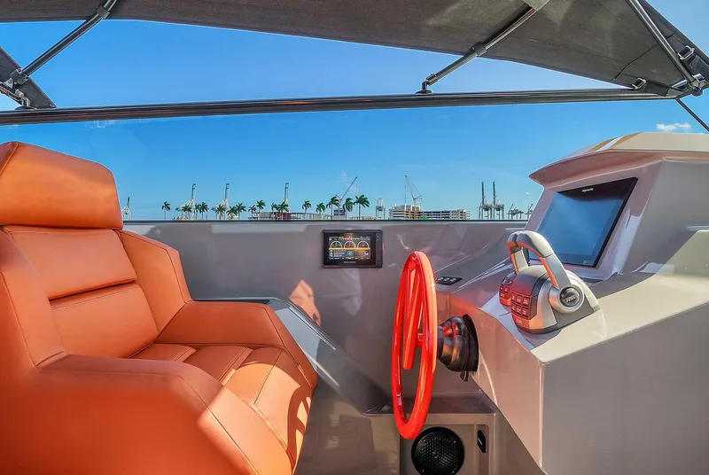 Slide: The Image of Interior of 2021 Vanquish Yachts VQ 45 with orange seating and modern helm controls. - 33