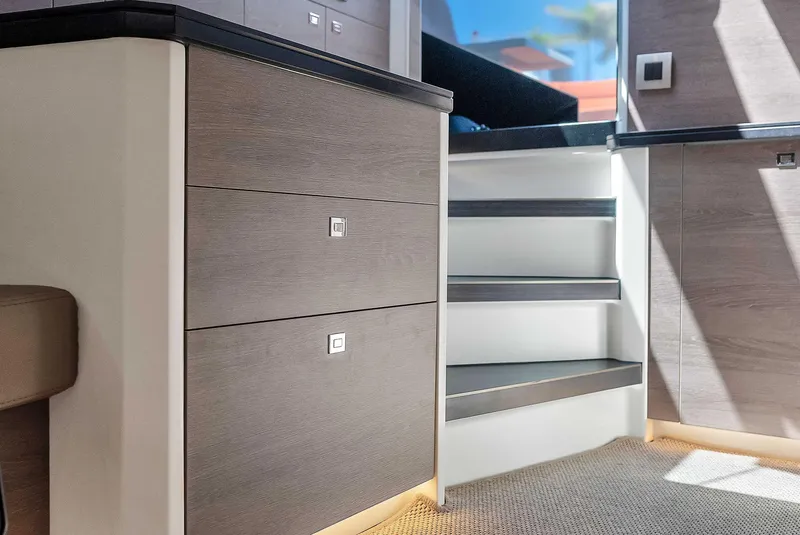 Slide: The Image of Interior of 2021 Vanquish Yachts VQ 45, featuring modern cabinetry and stairs. - 35