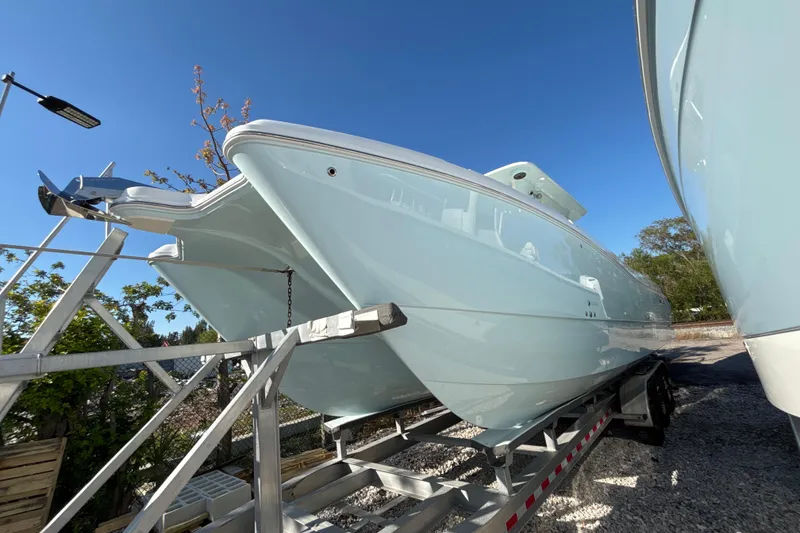 The Image of 2026 World Cat 325 CC boat on trailer under clear blue sky. - 1