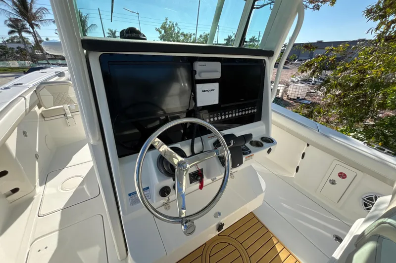 Slide: The Image of 2026 World Cat 325 CC boat cockpit with modern steering and navigation system. - 14