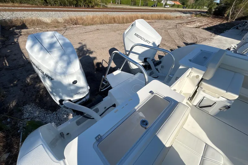 Slide: The Image of 2026 World Cat 325 CC boat with dual Mercury outboard engines, docked on sandy terrain. - 16