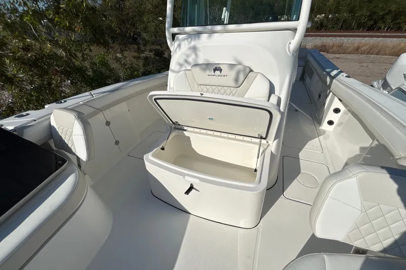 Slide: The Image of 2026 World Cat 325 CC boat interior with open storage compartment and cushioned seating. - 9