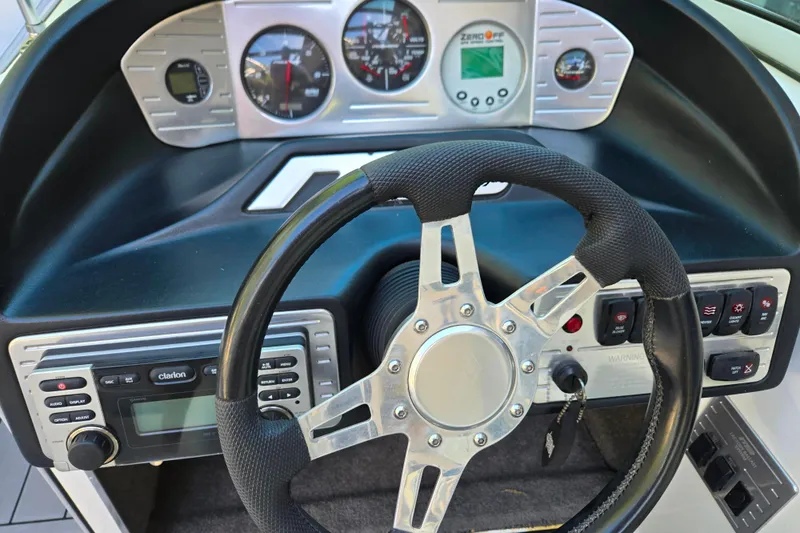 Slide: The Image of Dashboard of a 2010 MB SPORTS 21 Tomcat boat with steering wheel and gauges. - 10