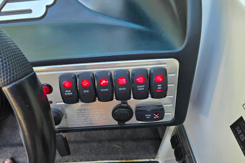 Slide: The Image of Dashboard controls of a 2010 MB SPORTS 21 Tomcat boat, featuring various switches. - 17