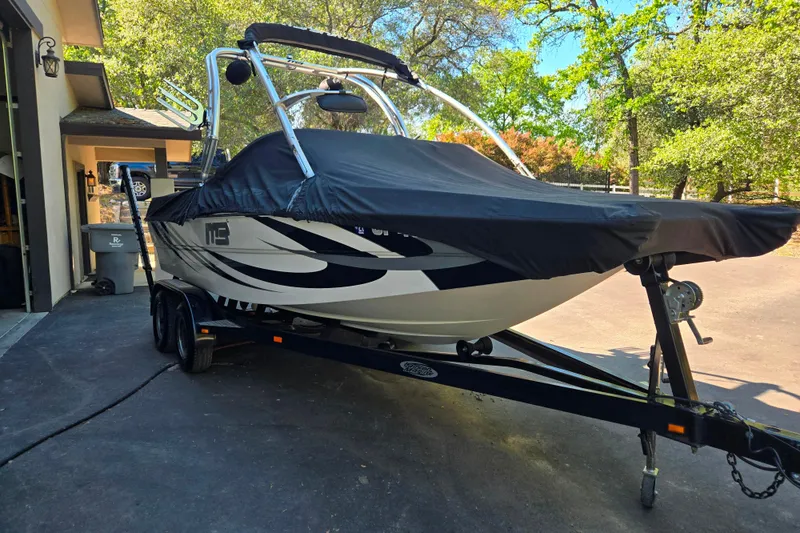 Slide: The Image of 2010 MB SPORTS 21 Tomcat boat on trailer with cover, parked in driveway. - 23