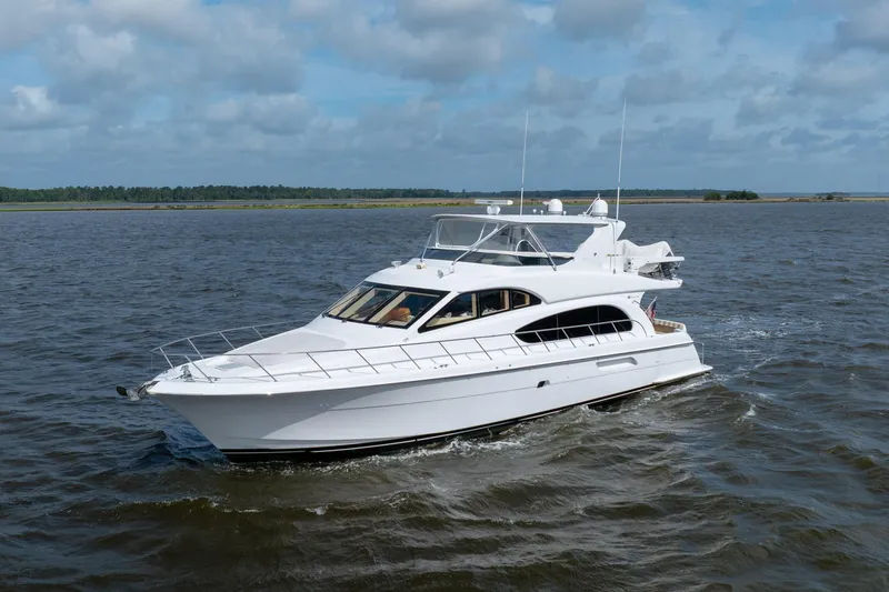 Slide: The Image of 2008 Hatteras 64 Motor Yacht cruising on open water under a cloudy sky. - 10