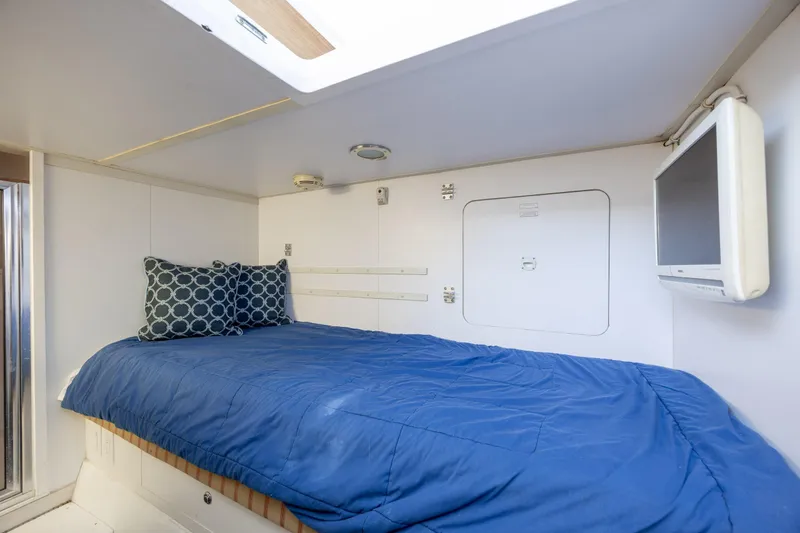 Slide: The Image of Cozy cabin interior of 2008 Hatteras 64 Motor Yacht with blue bedding and wall-mounted TV. - 108