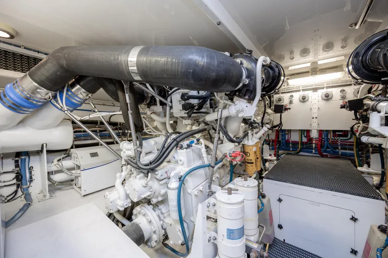 Slide: The Image of Engine room of 2008 Hatteras 64 Motor Yacht, showcasing complex machinery and piping. - 114
