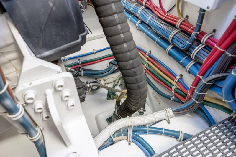 Slide: The Image of Engine room wiring of 2008 Hatteras 64 Motor Yacht, showcasing organized cables and hoses. - 119