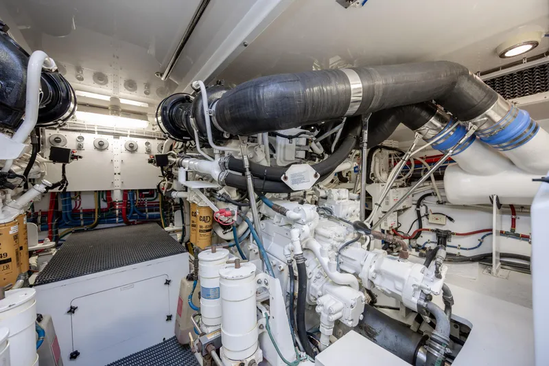 Slide: The Image of Engine room of 2008 Hatteras 64 Motor Yacht, showcasing complex machinery and piping. - 124
