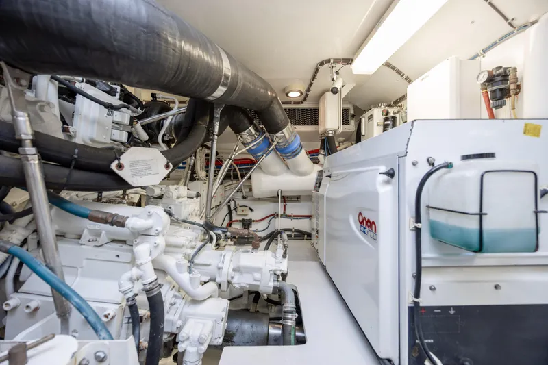 Slide: The Image of Engine room of a 2008 Hatteras 64 Motor Yacht, featuring Onan generator and complex piping. - 127