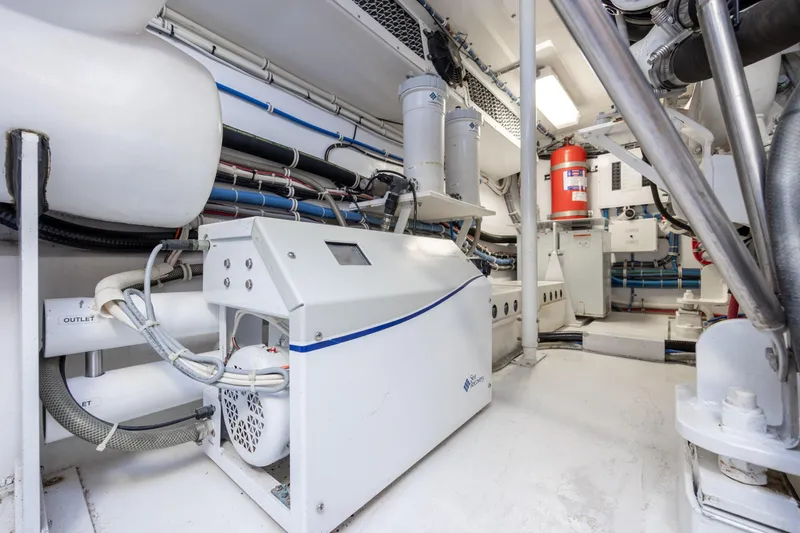 Slide: The Image of Engine room of 2008 Hatteras 64 Motor Yacht, featuring mechanical equipment and fire extinguisher. - 133