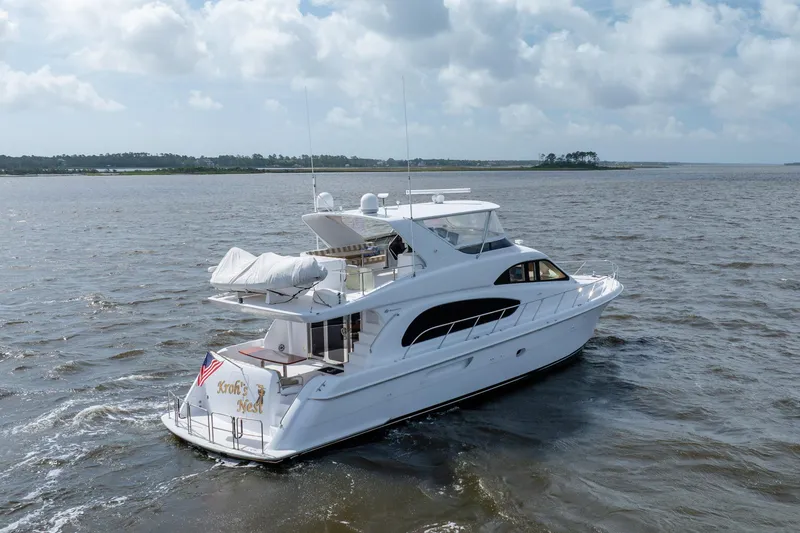 Slide: The Image of 2008 Hatteras 64 Motor Yacht cruising on open water under a cloudy sky. - 14