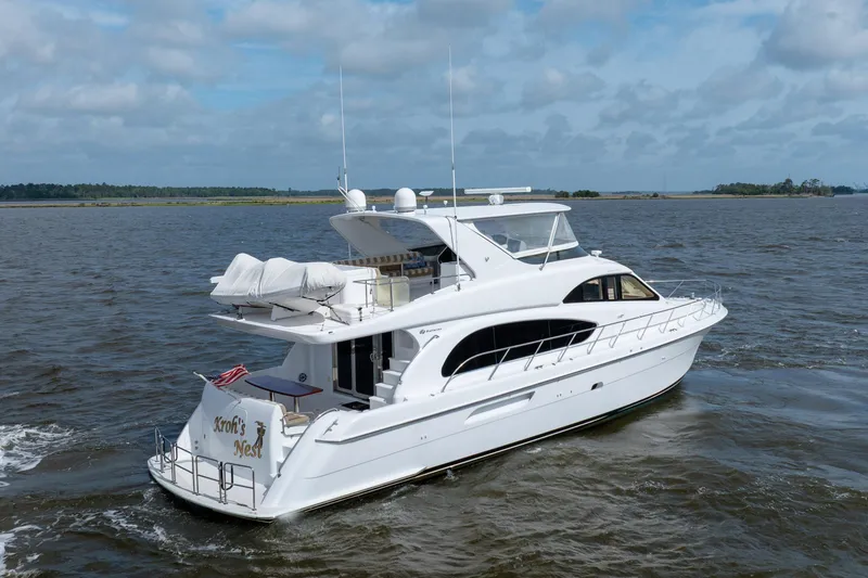 Slide: The Image of 2008 Hatteras 64 Motor Yacht cruising on open water under a cloudy sky. - 18