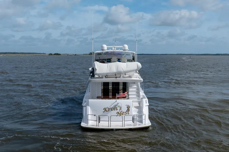 Slide: The Image of 2008 Hatteras 64 Motor Yacht cruising on open water under a cloudy sky. - 19