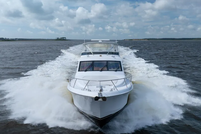 Slide: The Image of 2008 Hatteras 64 Motor Yacht cruising on open water under a cloudy sky. - 20