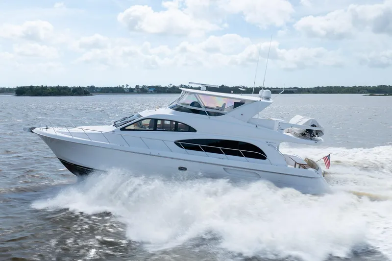 Slide: The Image of 2008 Hatteras 64 Motor Yacht cruising on open water under a cloudy sky. - 22