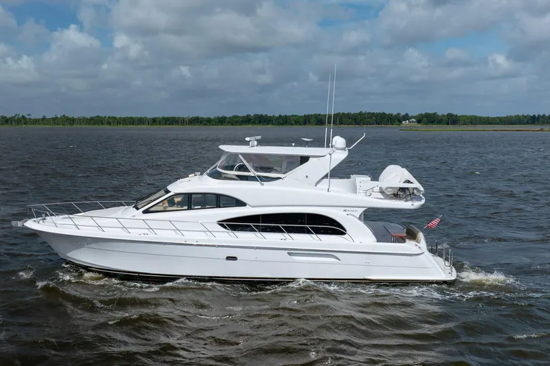 Slide: The Image of 2008 Hatteras 64 Motor Yacht cruising on open water under a cloudy sky. - 9
