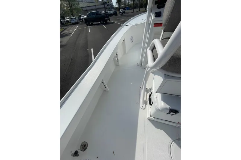 Slide: The Image of 2025 Sea Hunt BX 22 BR boat interior, featuring sleek white deck and seating in a parking lot. - 11