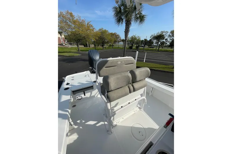 Slide: The Image of 2025 Sea Hunt BX 22 BR boat interior with seating, parked outdoors under clear sky. - 14