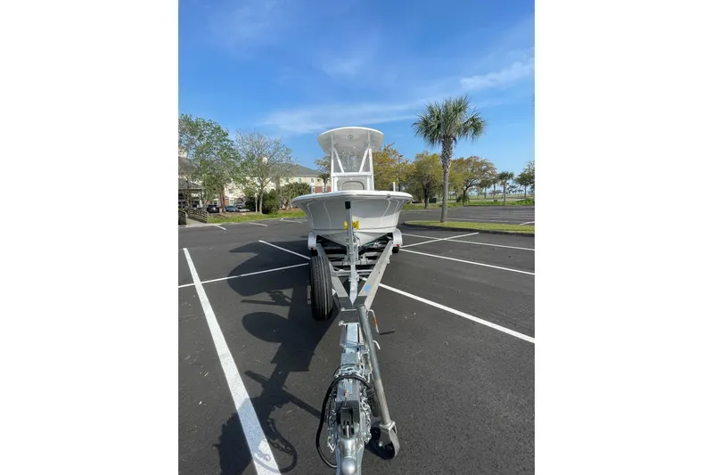 Slide: The Image of 2025 Sea Hunt BX 22 BR boat on trailer in parking lot, clear sky background. - 6