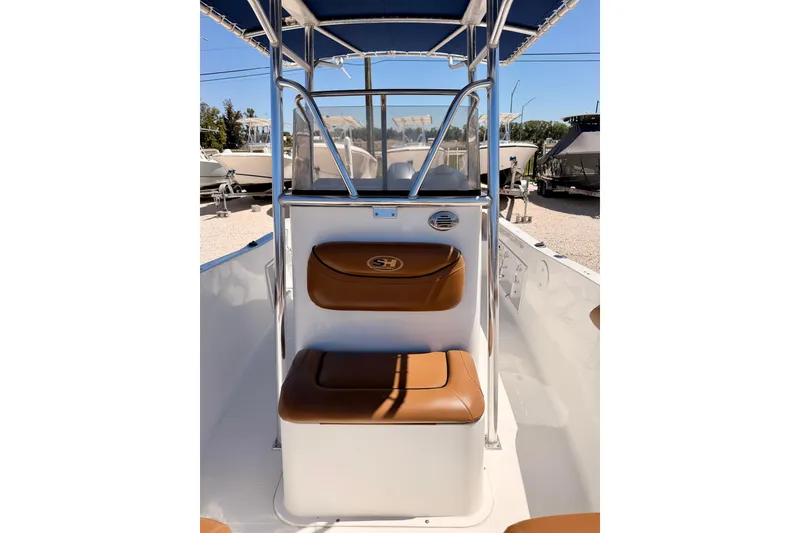Slide: The Image of 2010 Sea Hunt Ultra 210 boat interior with brown seating and blue canopy. - 12