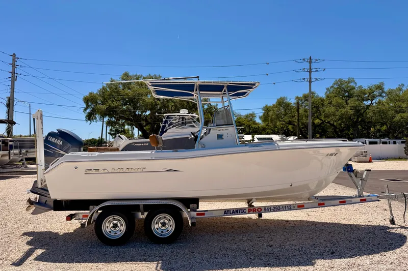 Slide: The Image of 2010 Sea Hunt Ultra 210 boat on trailer, side view, clear sky background. - 4