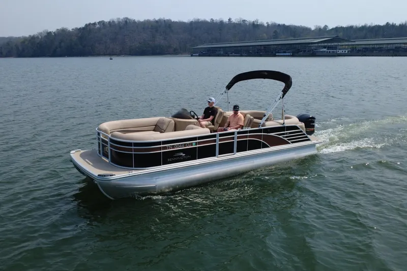 The Image of 2018 Bennington 23GSRFB pontoon boat cruising on a lake with passengers onboard. - 0