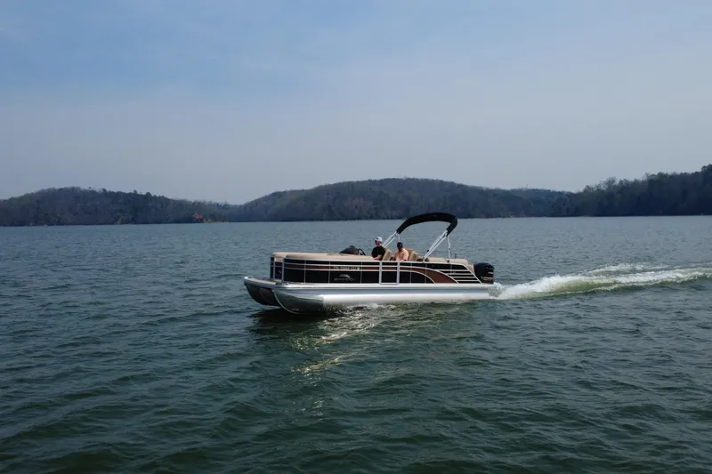 Slide: The Image of 2018 Bennington 23GSRFB pontoon boat cruising on a scenic lake. - 3