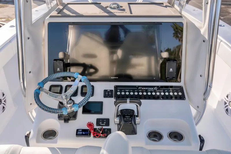 Slide: The Image of 2011 Freeman 33 boat dashboard with steering wheel, controls, and navigation display. - 11