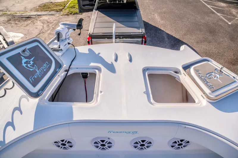 Slide: The Image of Freeman 33 boat deck with storage compartments, 2011 model, parked near a truck. - 16