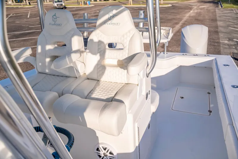 Slide: The Image of Luxurious seating on a 2011 Freeman 33 boat, featuring white cushioned chairs and stainless steel accents. - 18
