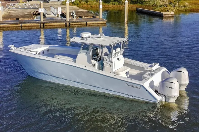Slide: The Image of Freeman 33 boat, 2011 model, docked with twin Yamaha engines in calm waters. - 2