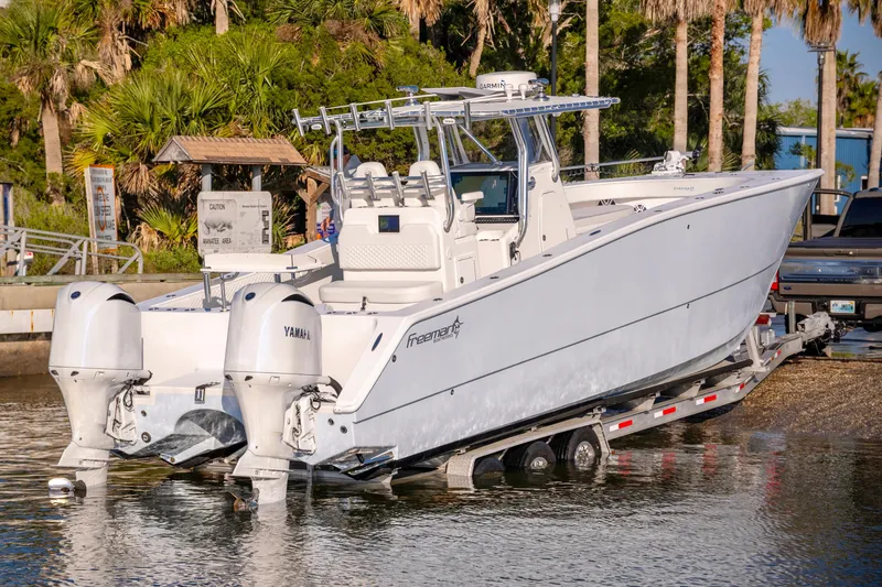 Slide: The Image of Freeman 33 boat from 2011 being launched into water, featuring twin Yamaha engines. - 8