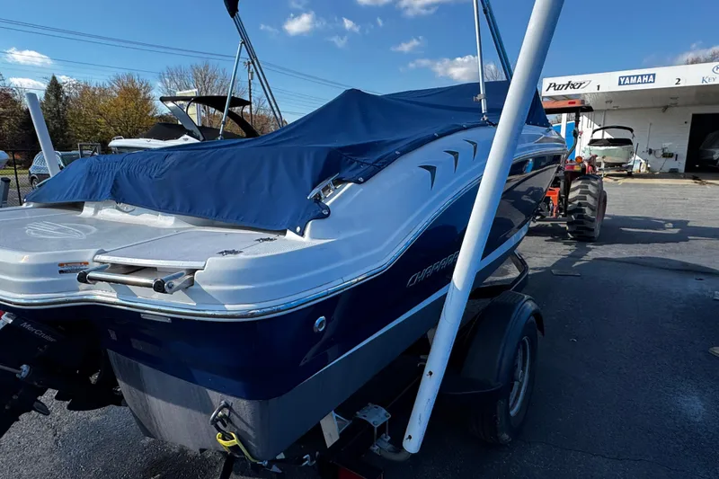 Slide: The Image of 2015 Chaparral 19 H2O Sport boat with blue cover, parked outdoors. - 12