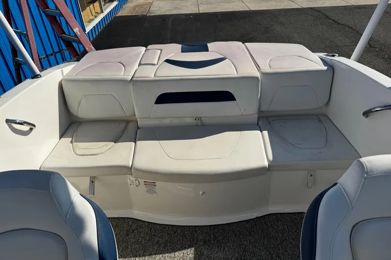Slide: The Image of 2015 Chaparral 19 H2O Sport boat interior with white seating and storage compartments. - 14